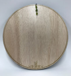Een licht gekleurde houten achterkant van een oceandrum voorzien van stippelpatroon en logo van Joke Zonneveld