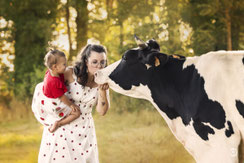 Photographe spécialisée animaux de compagnie: séance photo famille avec une vache.