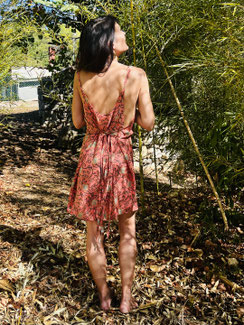 Robe courte en soie portée de dos par l’artiste Nine, dessinée par elle et confectionnée à la main en Inde par des artisanes. Une création fluide et élégante qui se porte de trois façons différentes selon l’envie et le style.