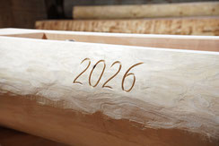 Detailansicht eines Brunnentrogs aus Lärchenholz mit eingravierter Jahreszahl 2026.