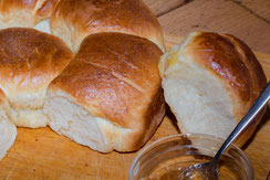 Französisches Brioche als Kranz angebrochen auf Holzbrett