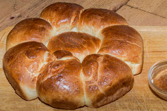 Französisches Brioche als Kranz auf Holzbrett