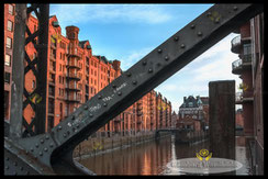 ein-blick-durch-die-bruecke-auf-das-wasserschloss-in-der-speicherstadt--hamburg-wandbilder