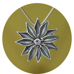 Bild:Sternblume als Schmuckanhänger aus Silber mit grünem ,kleinen Edelstein als Mittelpunkt