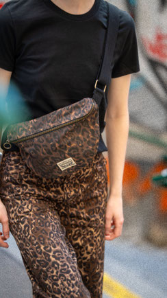 Nahaufnahme der Hose im Leo-Style, schwarzes-T-Shirt und Leo-Bag.