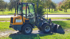 Radlader der auf einer Wiese steht