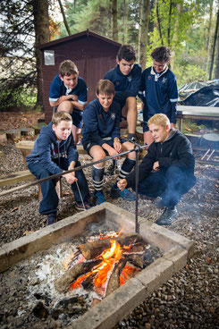 Groupe de jeunes garçons faisant un feu de camp dans leur collège anglais