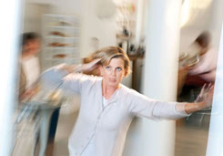 Hier befindet sich eine Abbildung von einer Fau, die einen Schwindelanfall erleidet und der Raum dreht sich um Sie