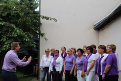 Probe im Bosenheimer Kirchgarten: Chorleiter Christian Baer (links) arrangiert den Chor „Klanglicht“ seit rund fünf Jahren. Foto: M. Ristow