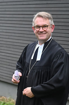 Propst Volker Mantey sät Blumen im neu angelegten Bibegarten auf Scheid am Edersee