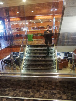 woman standing on the steps on a ferry, reflected in mirror