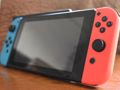 木目のテーブルの上に、青と赤のJoy-Conを装着したNintendo Switch本体が置かれている写真。Switch修理、画面修理、バッテリー交換、Joy-Con修理に関連する端末イメージ。