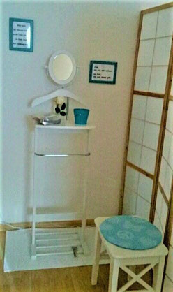 Herrendiener-Umkleide-mit-Bildern-und-Spiegel-und-Blume-in-Massageraum-Allschwil