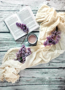 Buch, Tasse Kaffee und Blumen als Symbol für Inspiration, Wissen und ganzheitliche Ansätze