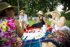 4 lachende Frauen auf einer Picknickdecke