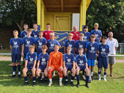Junge schießt Ball zum Trainer