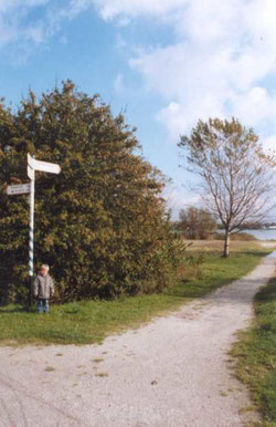 Mijn jongste zoon bij het fietspad en de wegwijzers