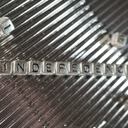 Silberne Scrabble-Steine bilden das Word "EINDEPENDANCE"