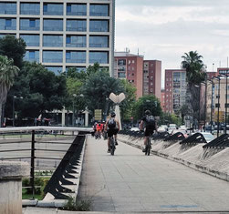Estos ciclistas van hablando por el Pont Nou d' Octubre en Valencia, mientras circulan por el puente como si fueran los putos amos.