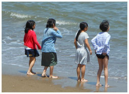 小学生が福祉ホテル「かしの木」に体験学習を行ったときの近くの海岸で遊んでいる様子。