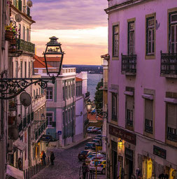 Lissabon in Abenstimmung - schmale Gasse im Abendlicht mit Blick auf das Wasser