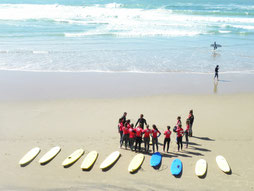 Manager qui apprend a un groupe a faire du surf avec de bonnes méthodes de coaching