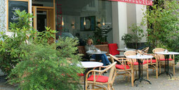 Eine junge Frau geniesst die Sonne bei Kaffee und Kuchen. Café beim Savignyplatz. Foto: Helga Karl