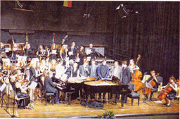 "Mozart meets Metallica": Pianisten und Teile des Orchesters beim abschliesenden Song "Halleluja". Rechts im Hintergrund der mitsingende Dirigent Marcin Grabosz. Foto: Paul Krahe