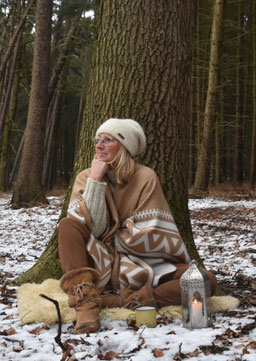 Eine Yoga-Lehrerin sitzt im schneebedeckten Wald