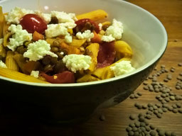 in einer Schale liegen Nudeln mit Linsen, Tomaten und Feta