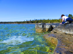 South shore of Lake Huron with boy looking at rocks.