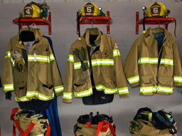 Row of firefighting jackets, helmets, and gear