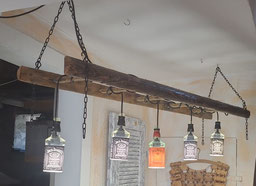 Handgemachte Balkenlampe aus alter Leiter mit LED-Fassungen und Körben aus Jack Daniels Flaschen.