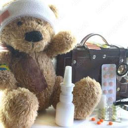 symbolische Reiseapotheke mit Teddybär