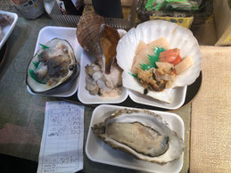 店頭で選んだ食材を調理してくれる。店奥で客同士がほとんど身動きできない状態で並んで立ち食い。ゆっくり食べたい気もするが、こういう雑多な感じがウケるのだろう。選んだのはカキセット、超美味!