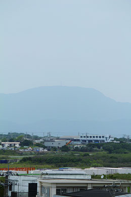 大陸からの黄砂の飛来で街並みがどんよりとした石垣島。於茂登岳はかすんで見えた=7日午後0時すぎ、県八重山事務所5階から撮影