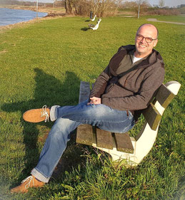 Op deze foto zie je onze lijsttrekker André Smit in het zonnetje zitten op een bankje langs de IJssel.
