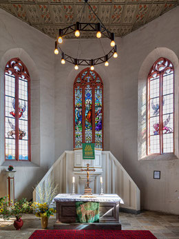Altarraum, links und rechts die Farbglasfenster von Fritz Körner mit den Symbolen der Evangelisten.