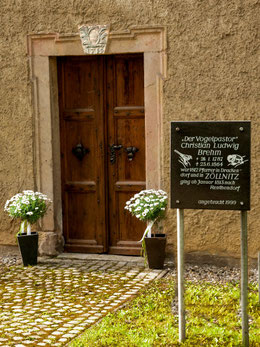 Eingangsportal mit dem Baujahr der Kirche, Erinnerungstafel an den Vogelpastor Christian Ludwig Brehm