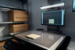 Ein Mitarbeiter in der Dokumentenaufbereitung entfernt Tackernadeln