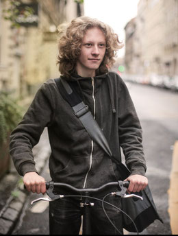 Junger Erwachsener mit Rad in Stadt