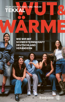 Auf dem Cover von "Wut & Wärme" stehen bzw. sitzen die Autorinnen vor einem Fenster.