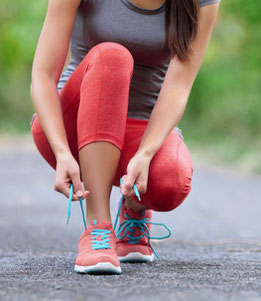 Sportlerin, die sich Laufschuhe anzieht 