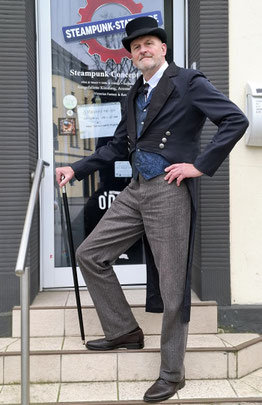Steampunk-Gentleman im Schwalbenschwanz-Gehrock mit passender Weste, Zylinder und elegantem Gehstock