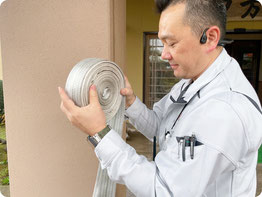 【写真】放水試験ホースの後片付け｜消防設備点検