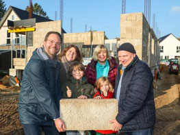 Familie Gifaldi und Familie Bremer mit einem Hanfstein auf ihrer Baustelle
