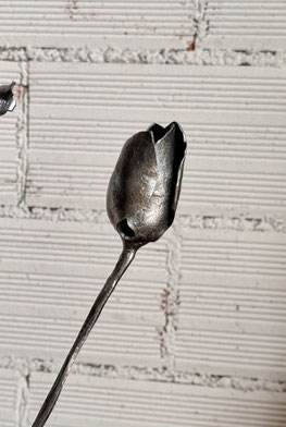 Tulipán de hierro cuidadosamente soldado, destacando como un detalle artesanal único.