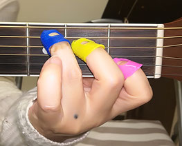 指サックをしてギターを弾いている画像