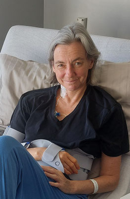 Reiterin Sigrid sitzt nach ihrem Reitunfall in ihrem Krankenhausbett, ihr rechter Arm in der Schlinge