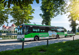 Der Bus Linie M mit Fahrradanhänger steht vor dem Schloss Moritzburg